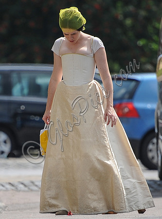 Claire Foy arriving only partly dressed with head lowered and hair in a net.