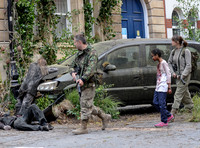 Paddy Considine, Sennia Nanua and Gemma Arterton on a dystopian street in fatigues carrying guns