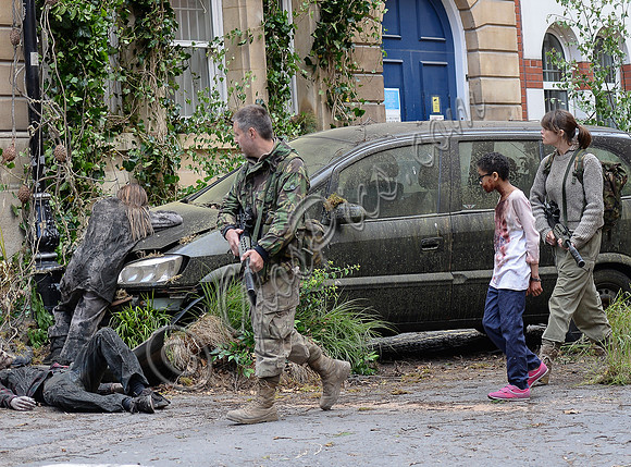 Paddy Considine, Sennia Nanua and Gemma Arterton on a dystopian street in fatigues carrying guns