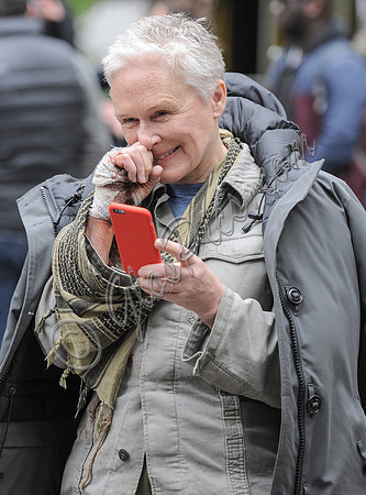 Glen Close reading text messages on phone smiling
