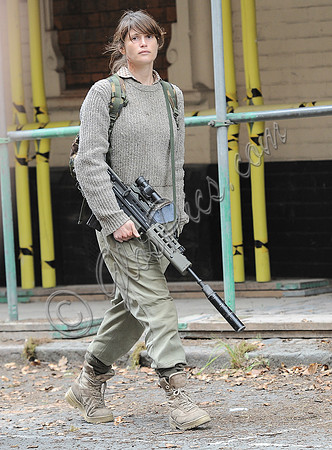 Gemma Arterton in fatigues carrying rifle