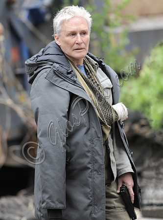 Glenn close waist up, bandaged hand with parka draped over shoulders