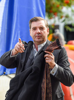 Brendan Coyle carrying a jacket and tie in left hand and gesticulating with his right.