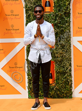 Tinie Tempah wearing white and black hands held in prayer