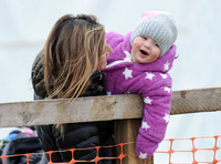 Dolly Maude hols a smiling Mia Tindall wearing pink and white onepiece suit and woolly hat