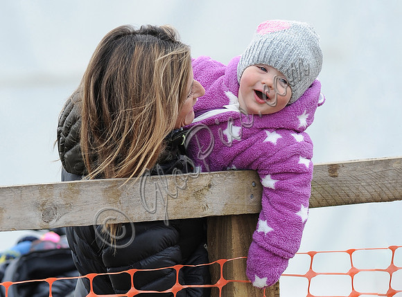 Dolly Maude hols a smiling Mia Tindall wearing pink and white onepiece suit and woolly hat