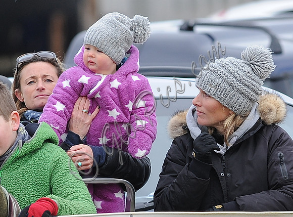 Dolly Maude holdsup  Mia Tindall to watch races alongside Zara Phillips wearing matchin wooly hats.