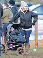 Zara Phillips wearing woolly hat, with daughter in blue buggy.