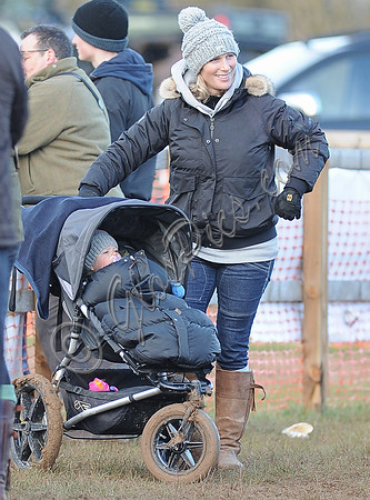 Zara Phillips wearing woolly hat, with daughter in blue buggy.