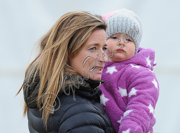 Dolly Maude holding Mia Tindall wearing pink and white onepiece suit and woolly hat