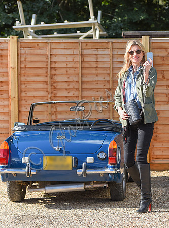 Kate Moss wearing military style jacket, teamed with denim shirt, black skinny jeans, tall Christian Laboutin leather boots carrying a vintage Chanel quilted flap bag.