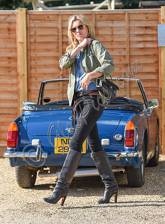 Kate Moss wearing military style jacket, teamed with denim shirt, black skinny jeans, tall Christian Laboutin leather boots carrying a vintage Chanel quilted flap bag.