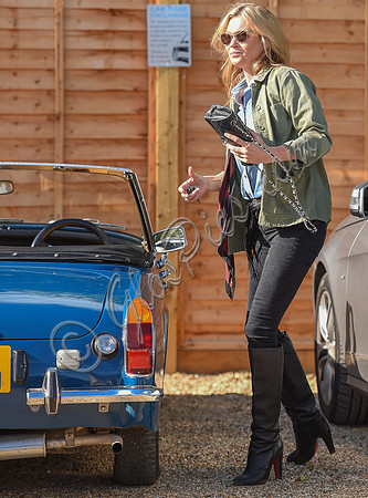 Kate Moss wearing military style jacket, teamed with denim shirt, black skinny jeans, tall Christian Laboutin leather boots carrying a vintage Chanel quilted flap bag.