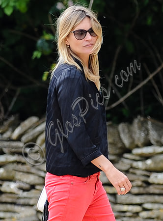 Kate Moss wearing black pyjama blouse and coral jeans