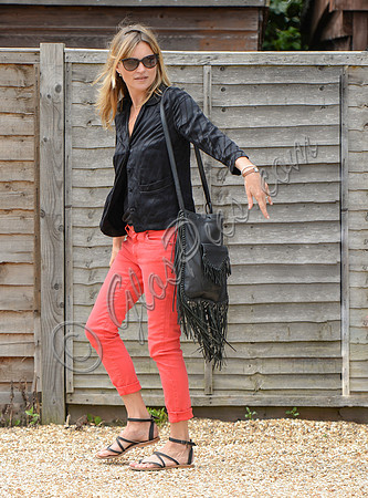 Kate Moss wearing black pyjama blouse and coral jeans