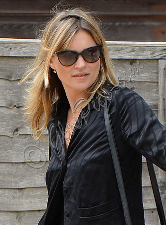 Kate Moss close up wearing sunglasses and black pyjama blouse