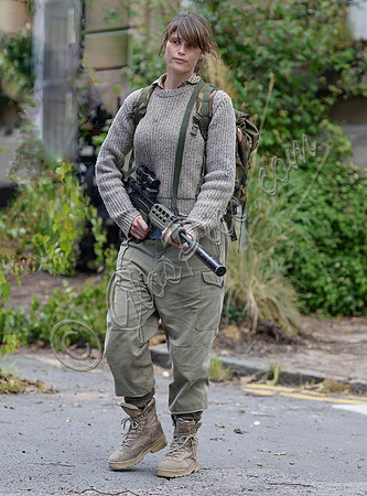 Gemma Arterton in fatigues carrying rifle