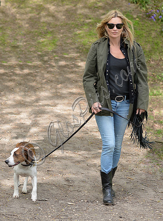 Supermodel Kate Moss wearing military style jacket, skinny jeans and cowboy boots takes a walk with her dog Archie in the woods