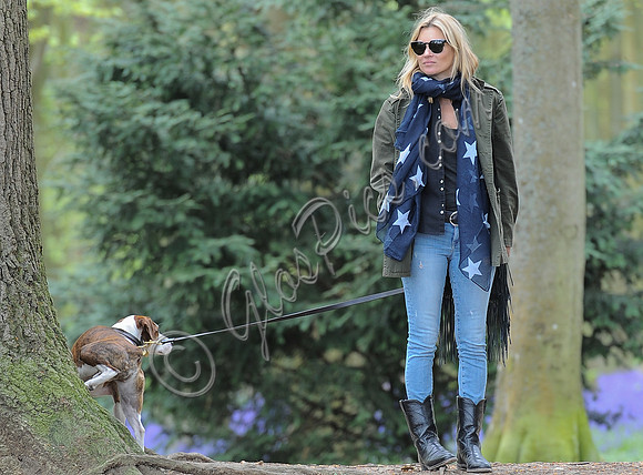 Supermodel Kate Moss wearing military style jacket, skinny jeans and cowboy boots takes a walk with her dog Archie in the woods