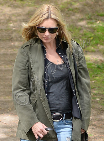 Supermodel Kate Moss wearing military style jacket, skinny jeans and cowboy boots takes a walk with her dog Archie in the woods
