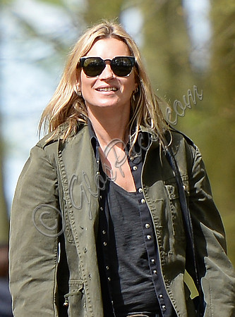 Supermodel Kate Moss wearing military style jacket, skinny jeans and cowboy boots takes a walk with her dog Archie in the woods