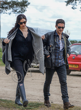 Liv Tyler in grey poncho and blue Hunter wellies with partner Dave Gardner at Badbury Clump