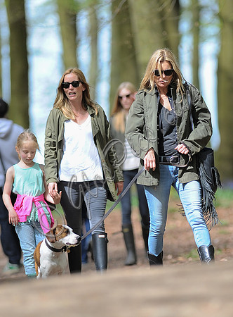 Supermodel Kate Moss wearing military style jacket, skinny jeans and cowboy boots takes a walk with her dog Archie and some pals  in the woods