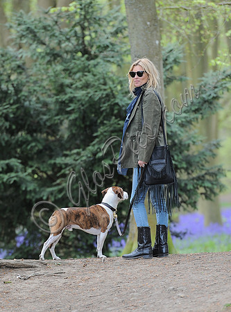 Supermodel Kate Moss wearing military style jacket, skinny jeans and cowboy boots takes a walk with her dog Archie in the woods