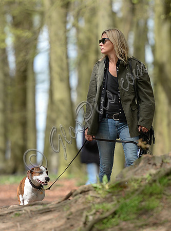 Supermodel Kate Moss wearing military style jacket, skinny jeans and cowboy boots takes a walk with her dog Archie in the woods